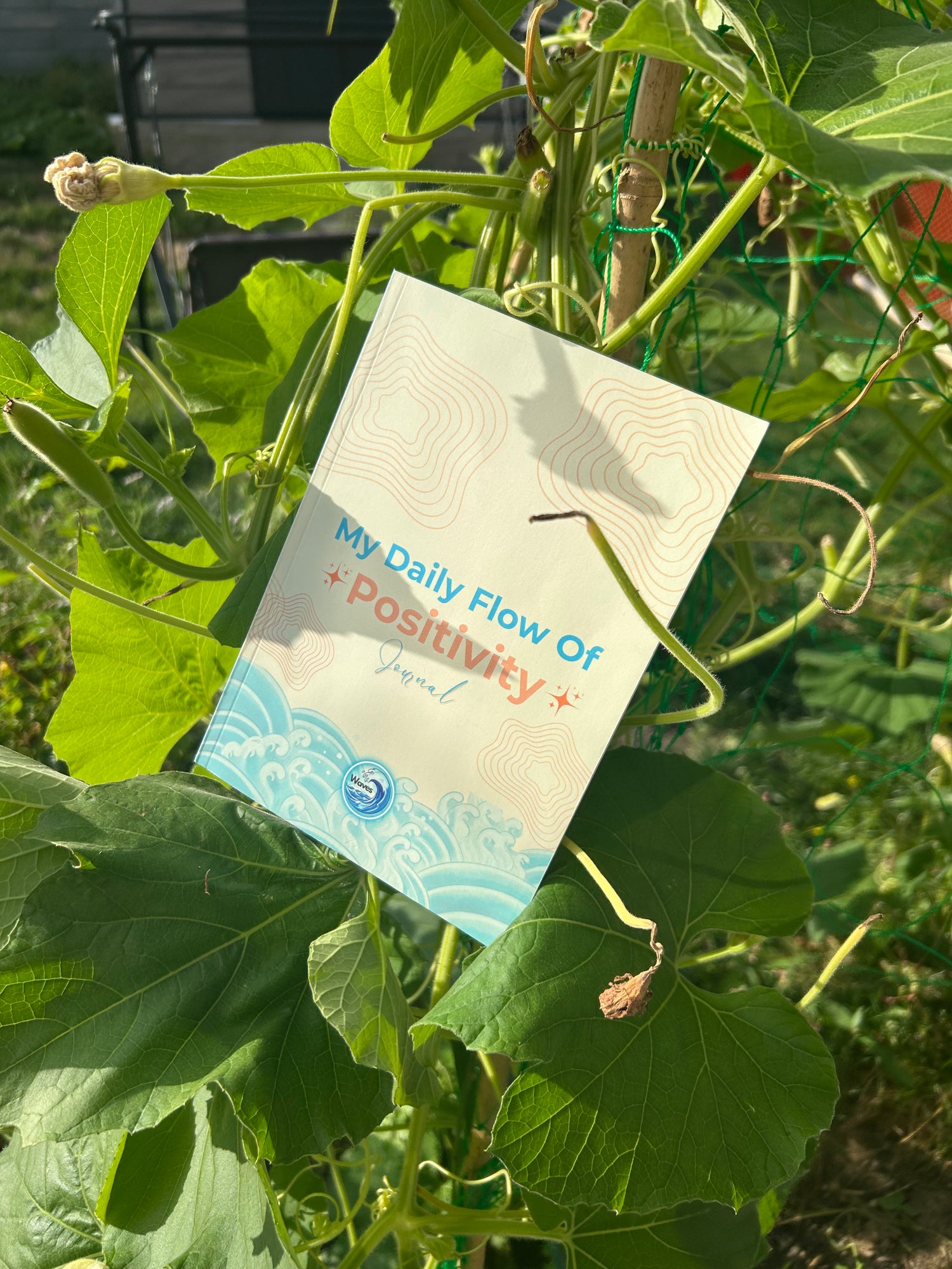 journal with 'Flow of Positivity' text among green leaves