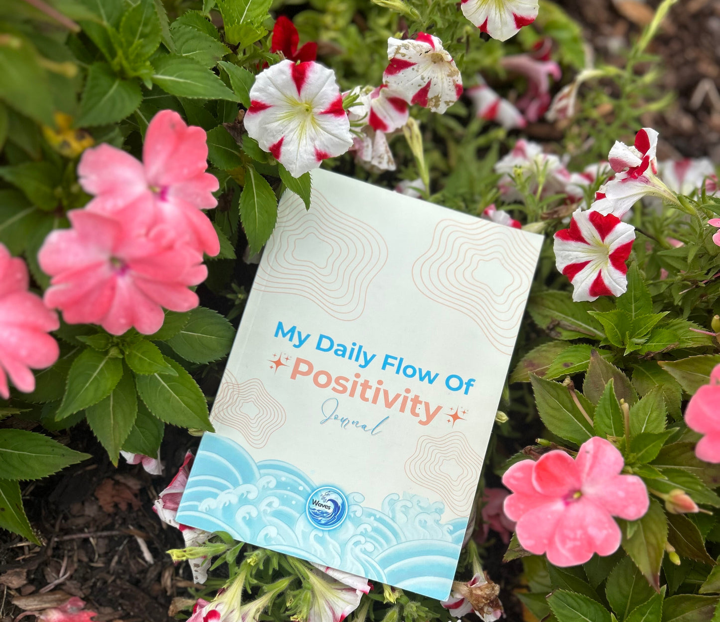 Journal titled 'My Daily Flow of Positivity' surrounded by pink and white flowers.