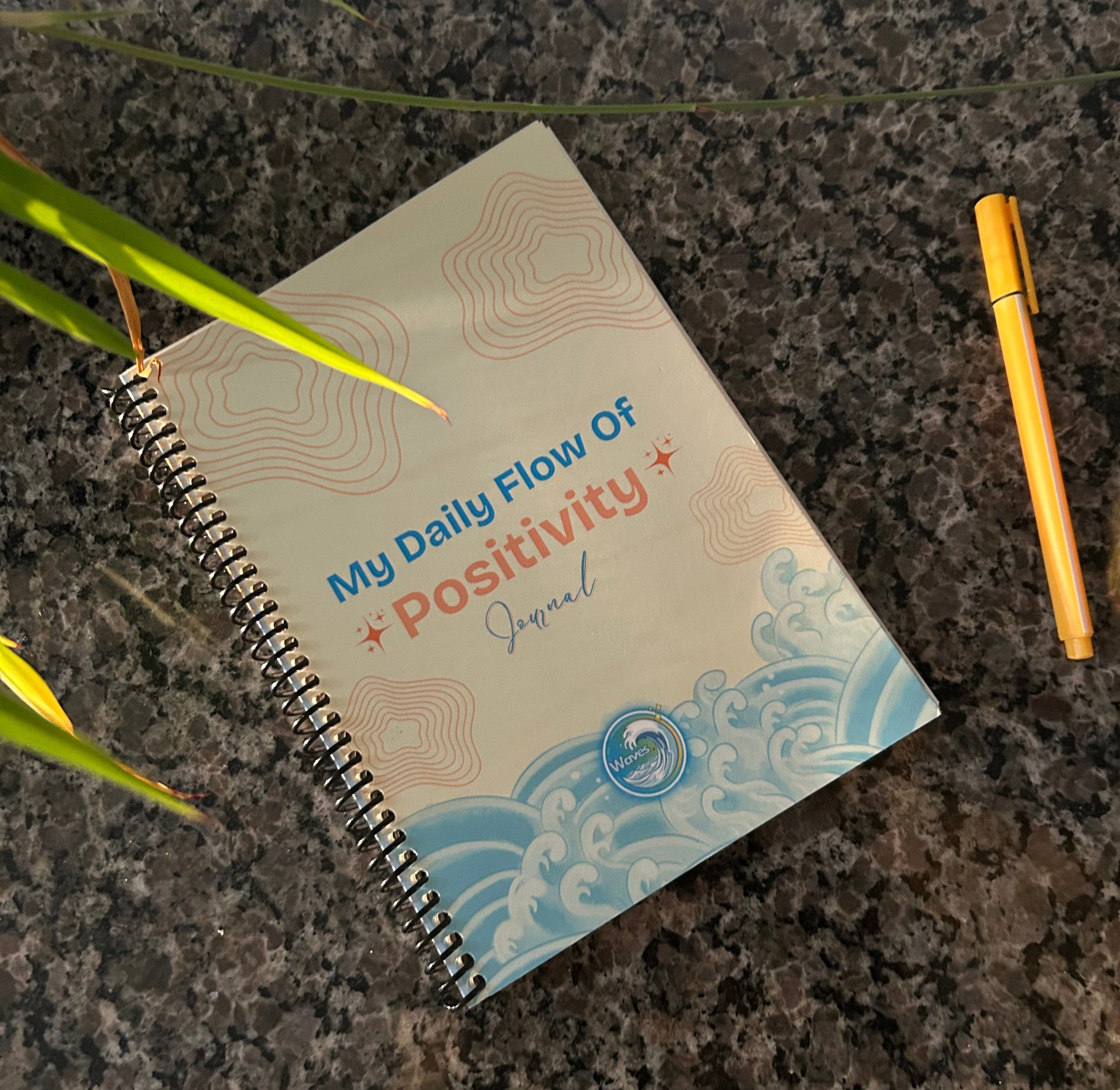 waves wellness guided flow journal on a marble background with a pen and plant.